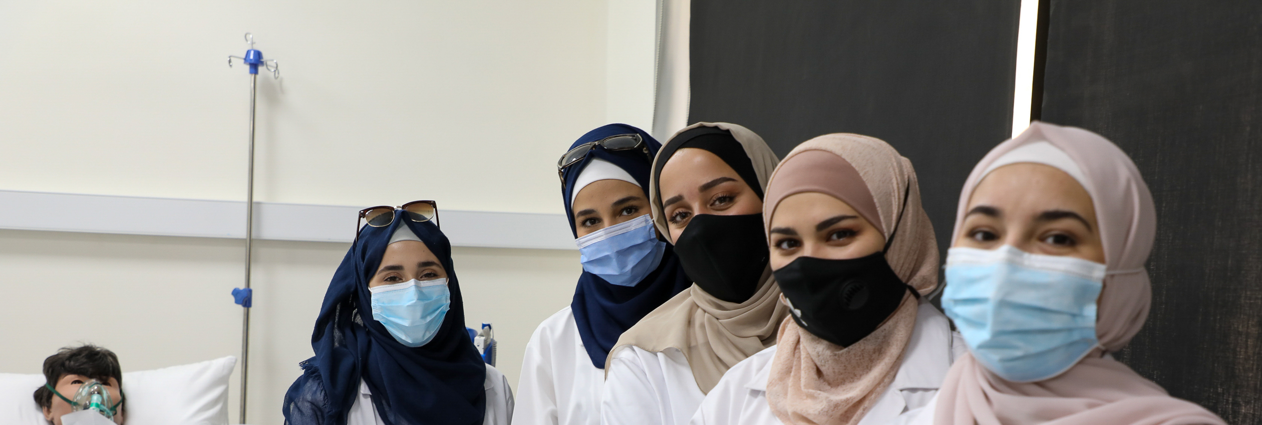 Group of nurses look at camera. Syrian refugee students study nursing in Jordan.