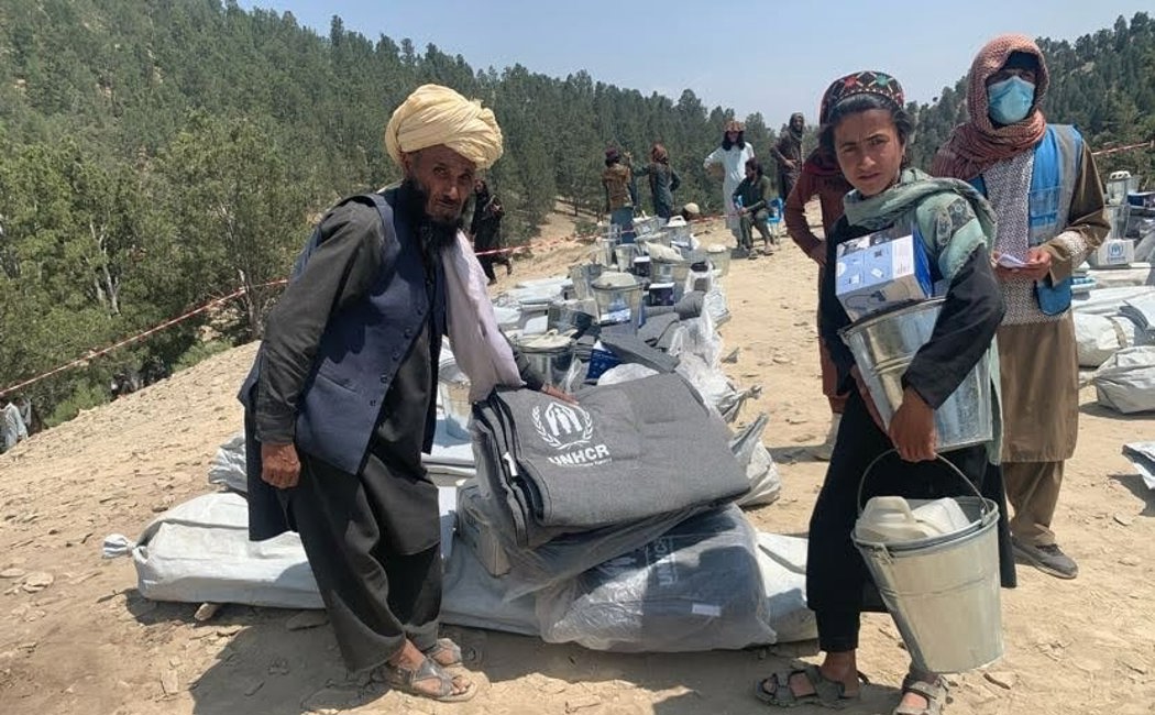 A family collects a relief items kit from the UNHCR distribution point in Khost Province following an earthquake.