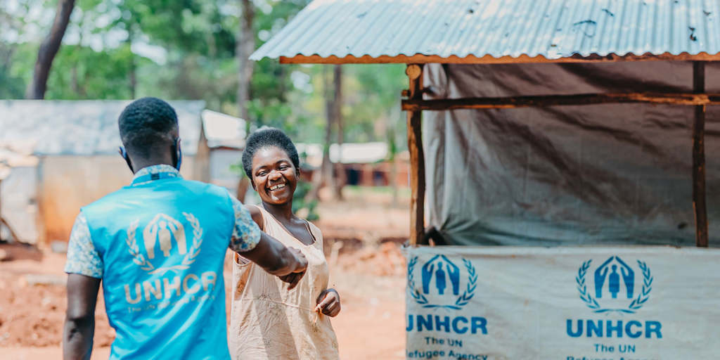 UNHCR staff worker greets a smiling refugee woman in Tanzania’s Nduta camp