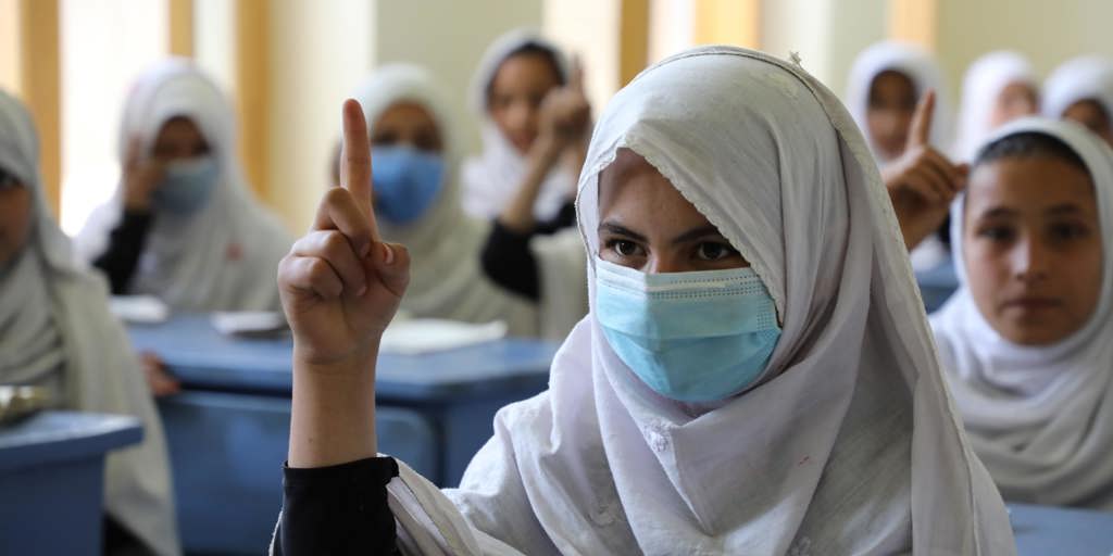 A student raises her hand in class at the girls’ high school built with UNHCR support in the Saracha area of the eastern Afghan city of Jalalabad.