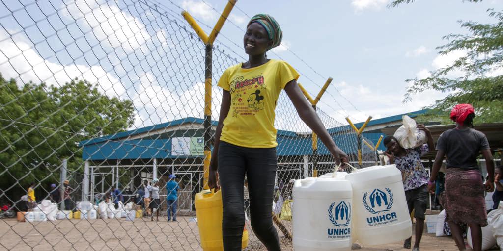 A South Sudanese refugee at Kakuma camp in Kenya walks home after collecting her new 20-litre jerrycans as the settlement acts to manage the coronavirus threat.