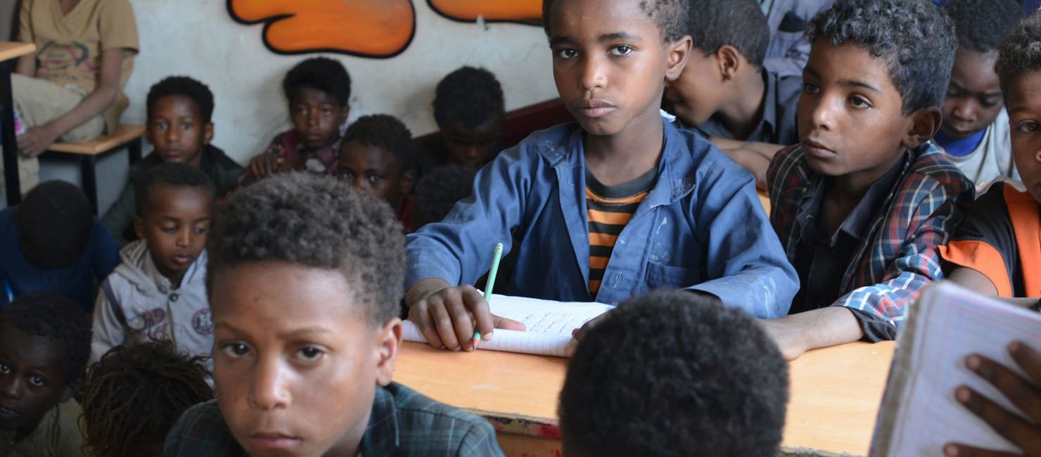 Boy sitting in a classroom at a UNHCR-rehabilitated school in Yemen.