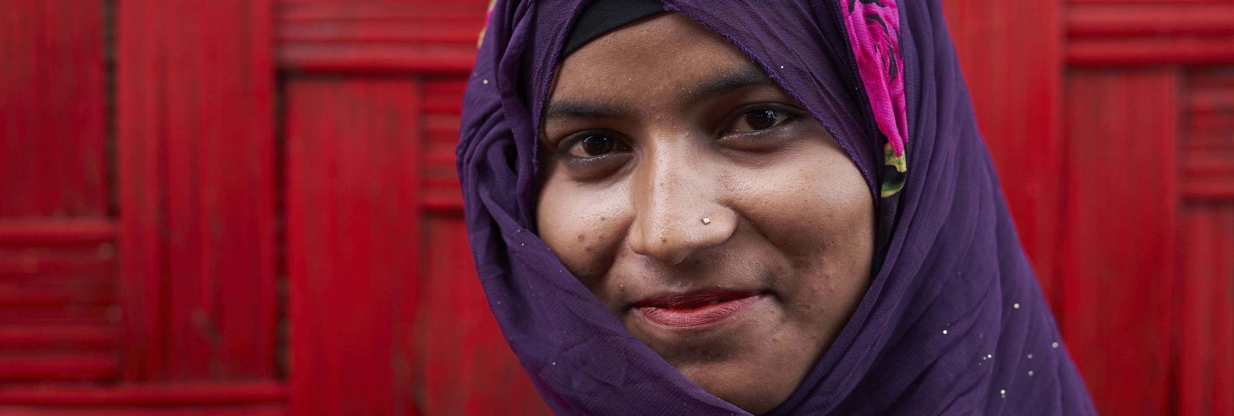 Rozaina Akhtar, 18, poses for a photograph outside the Dream Garden Adolescent Club, a safe space for Rohingya refugee women between the ages of 15-24, where she is one of the co-facilitators, in Camp 4, at the Kutupalong Expansion Site for Rohingya refugees, Ukhia, Cox's Bazar District, Bangladesh.