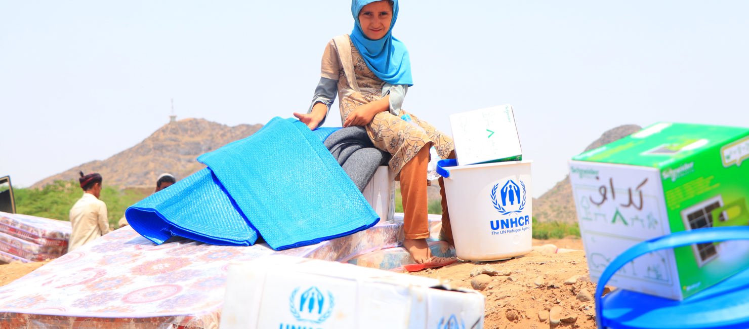 Child with UNHCR supplies. Displaced families in Yemen receive essential household items.