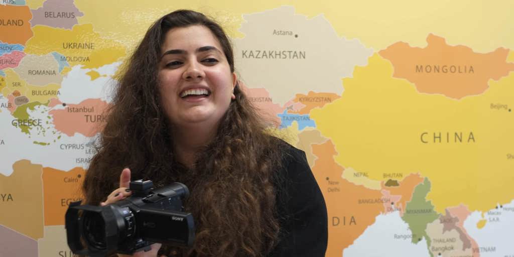 Winner of 2022 Australia for UNHCR Beddie Scholarship holding camera.