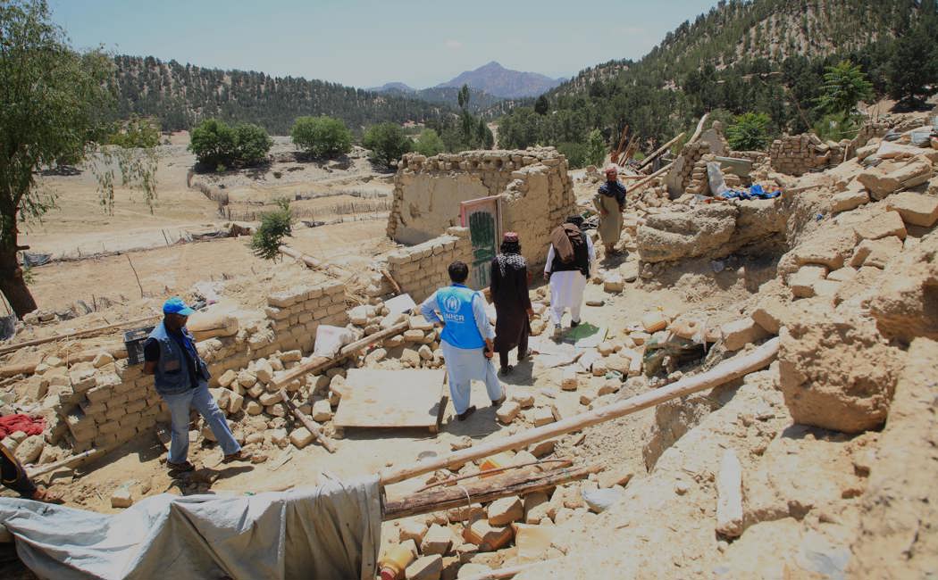A UNHCR earthquake assessment team walks through the rubble following an earthquake in Spera District, Khost Province. 