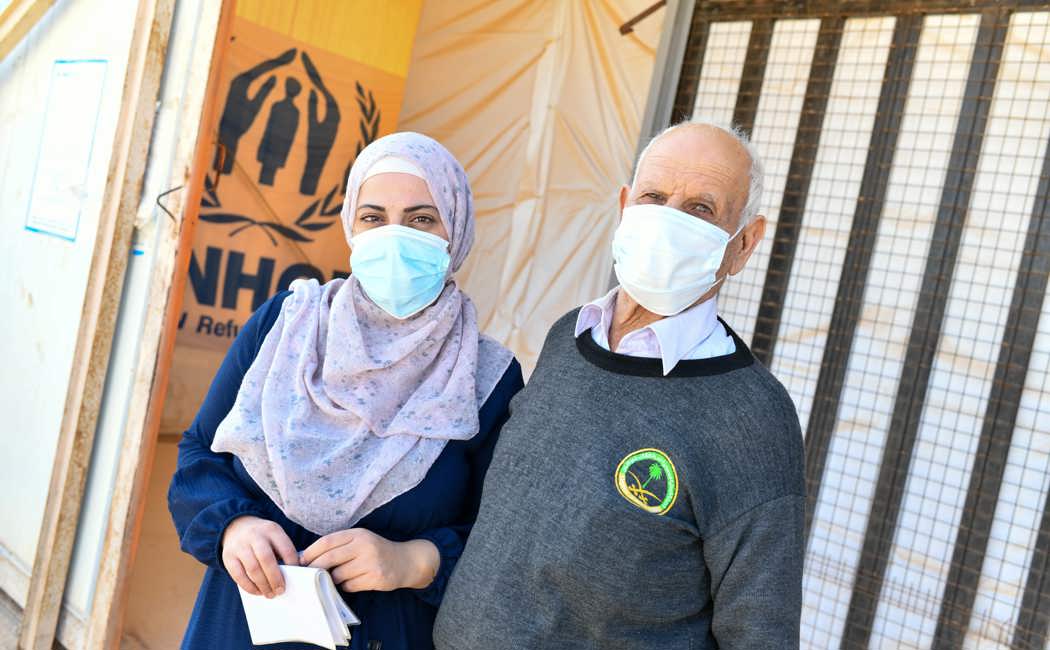 Shatha, 35, and her father Abu Safwan, 75, receive their winter cash assistance in Azraq Camp.