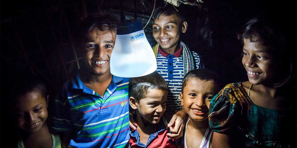 Young children in Bangladesh gather round a solar lamp at night | Ramadan charity gifts