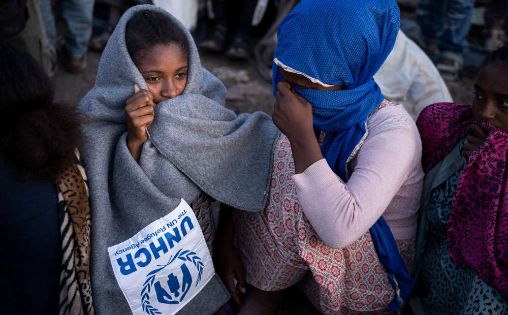An Ethiopian refugee woman wraps herself in a UNHCR blanket. 