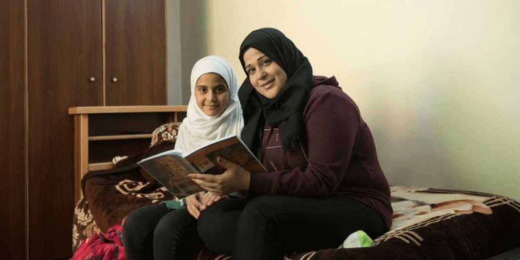 Hanaa 27, helps her daughter Joudy, 13 with her homework 