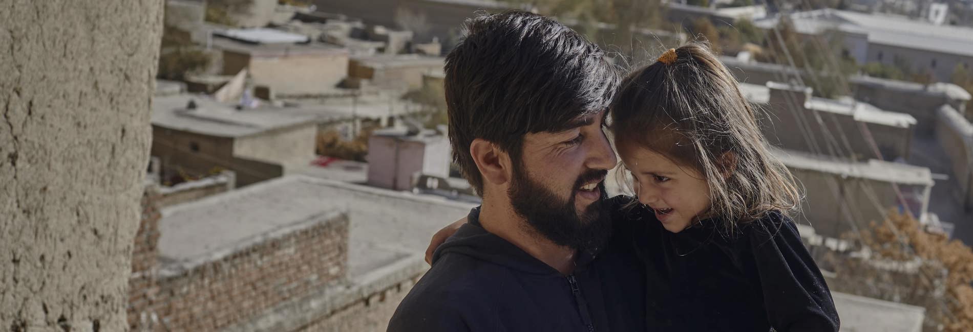 Abdul Sattar*, 30, holds his daughter Munawara, 4, outside their accommodation in Kabul.